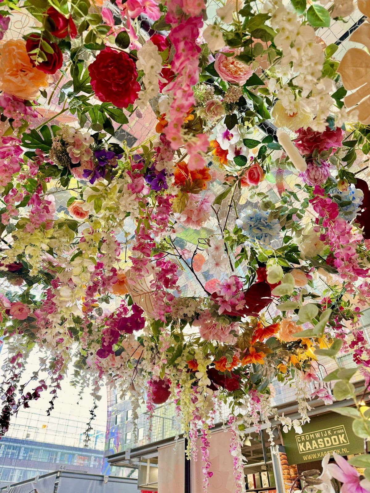 Hanging floral and light installation above a dining space