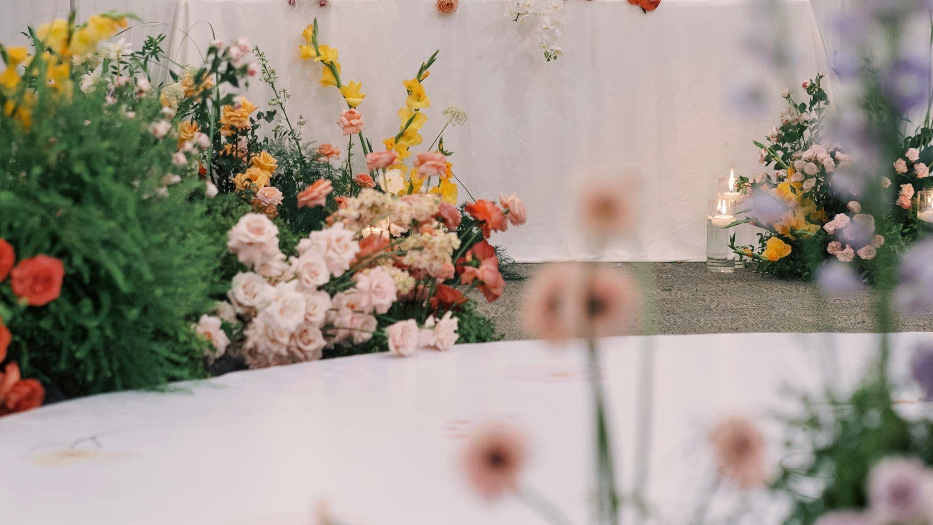 Reception stage with layered drapery and floral framing