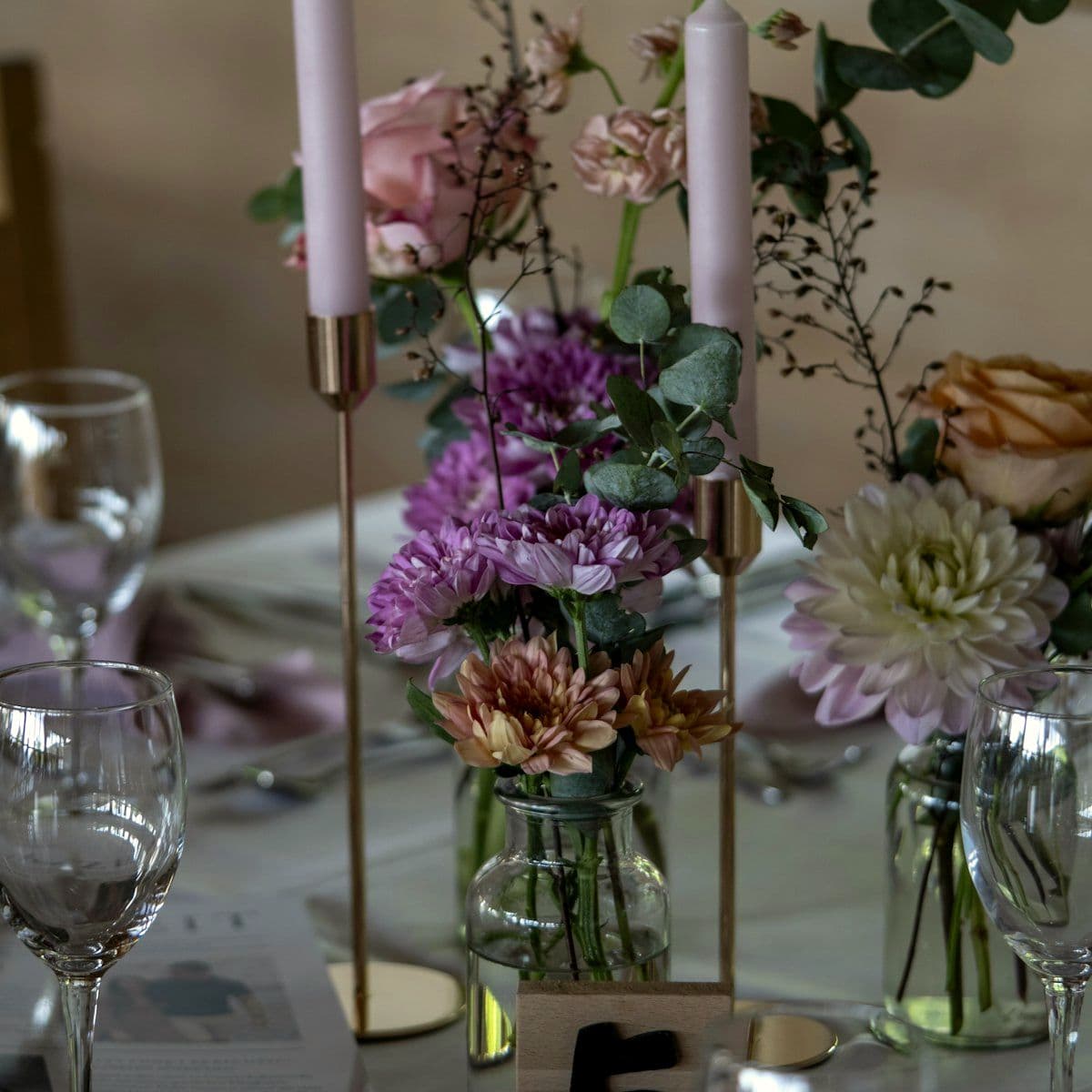 Tablescape with candles, glassware and low centrepieces