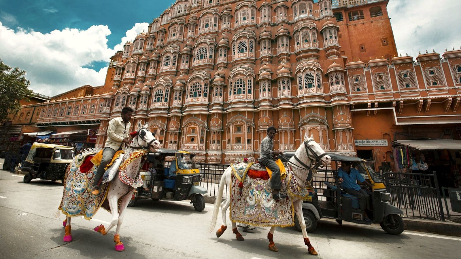 Decorated horses passing a Rajasthan palace facade