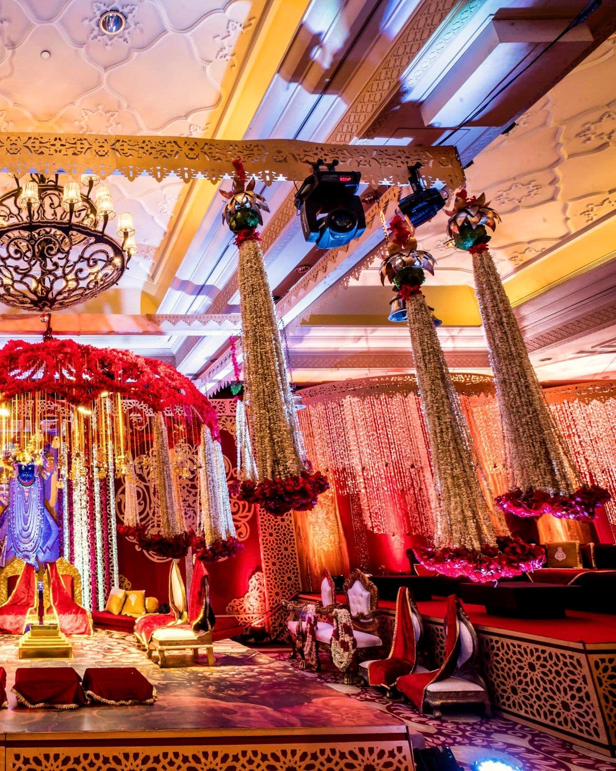 Ceremony stage with chandeliers and layered floral work