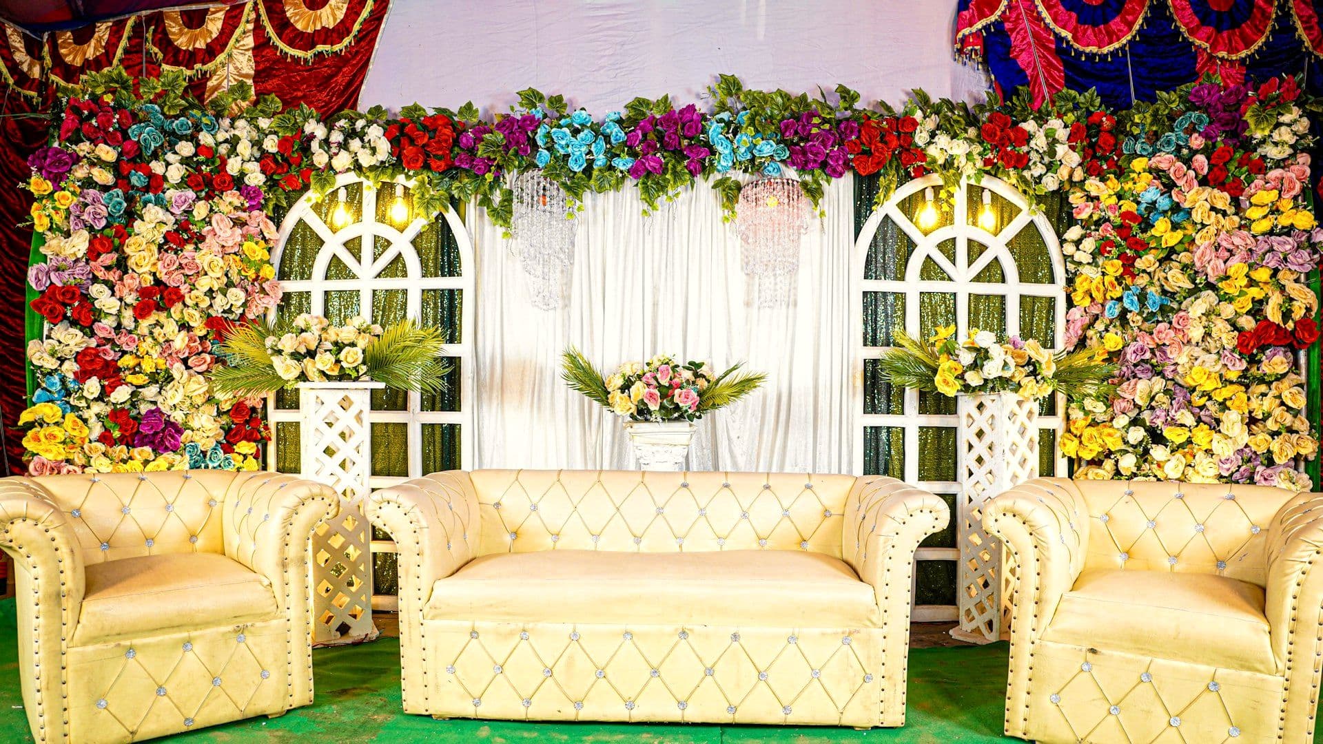 Reception stage with seating framed by floral arches