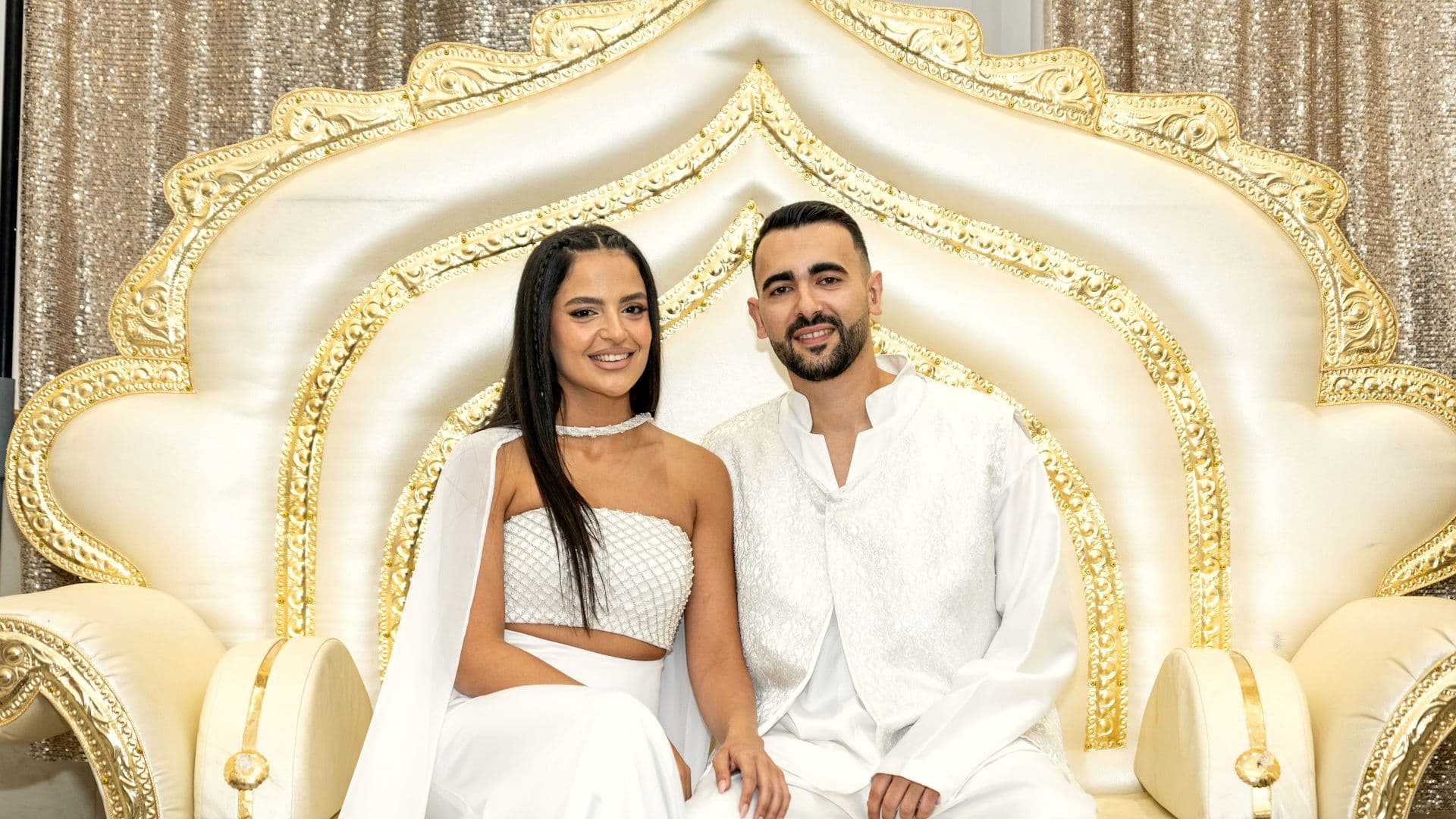Couple seated on the reception stage with the family