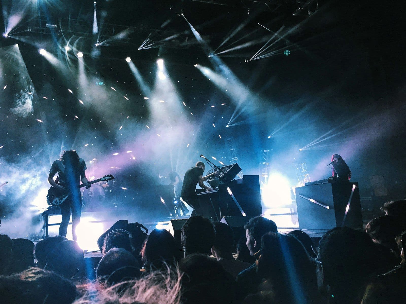 Live band performing on stage under coloured lighting