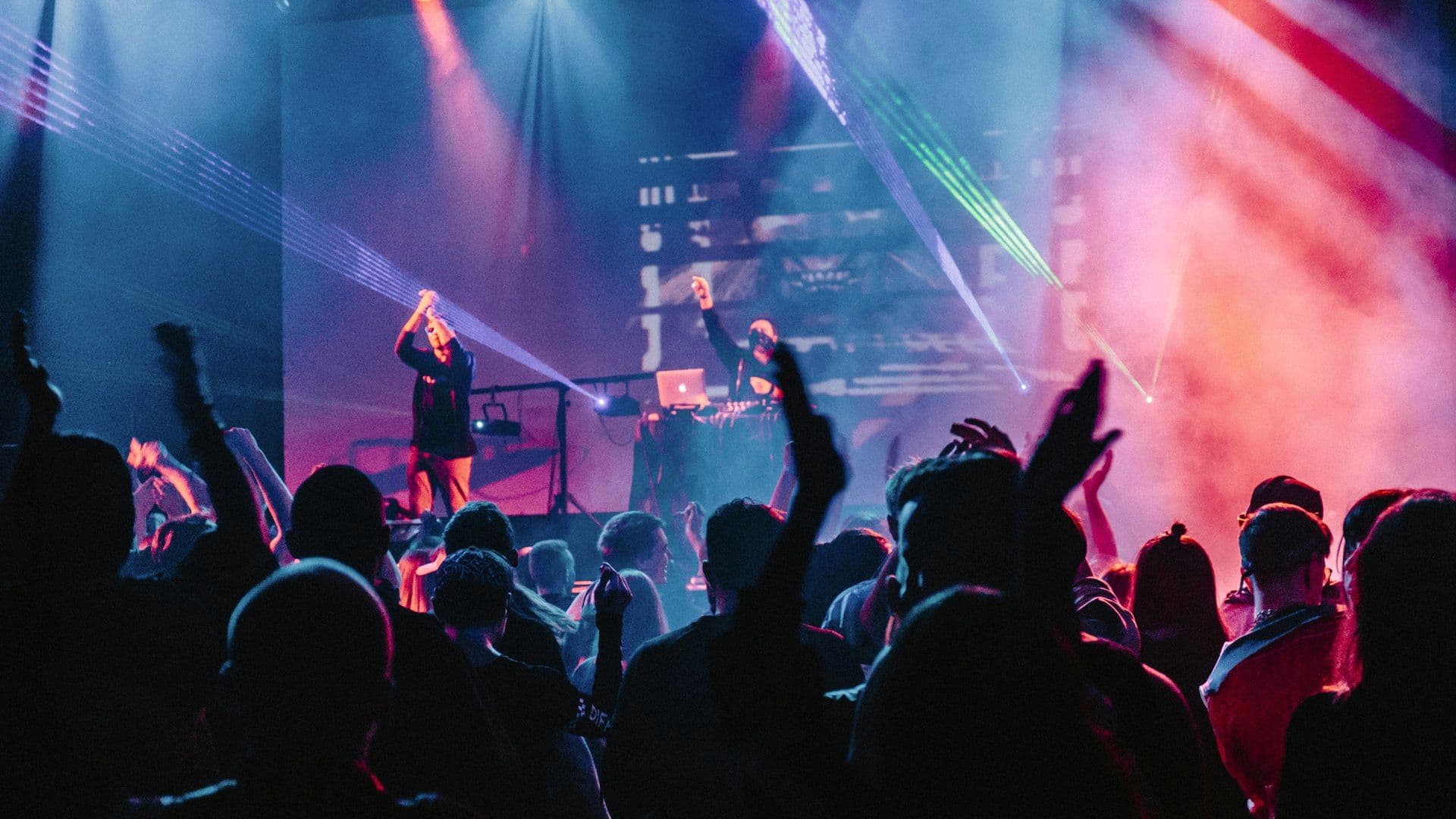 Crowd with hands raised in front of the stage