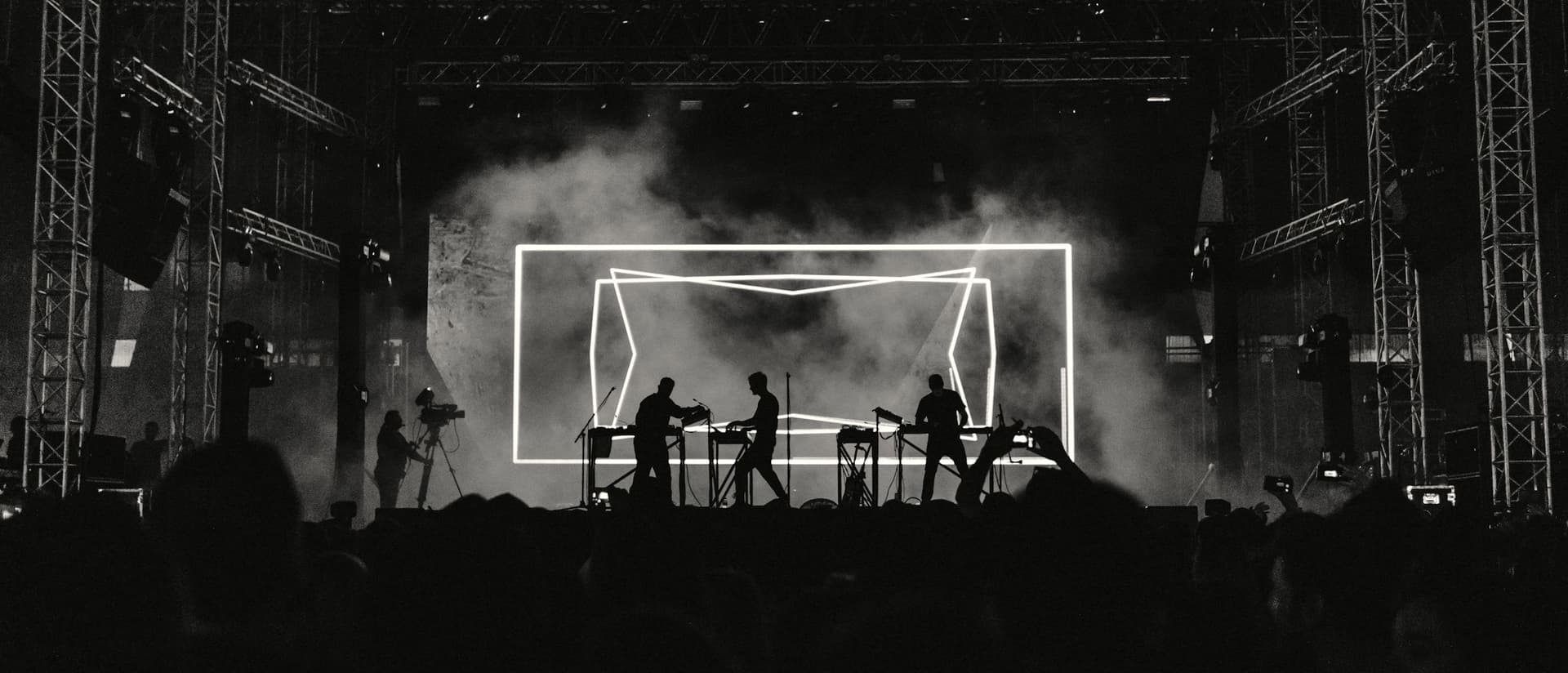 Silhouetted band performing on a concert stage