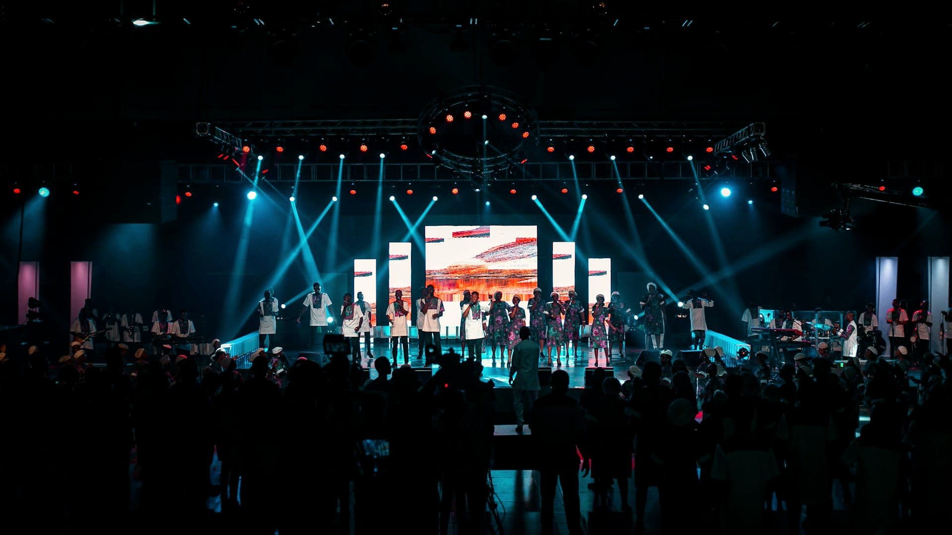 Employees on stage under production lighting at an annual day