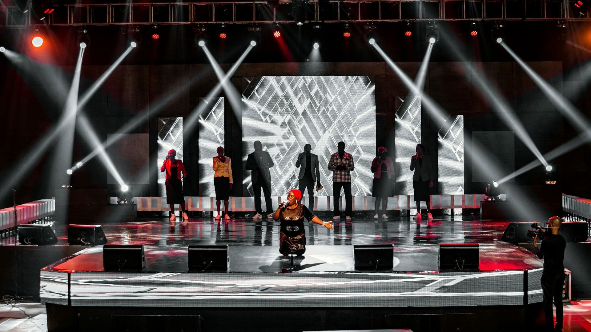 Performers on a lit stage at a large evening production