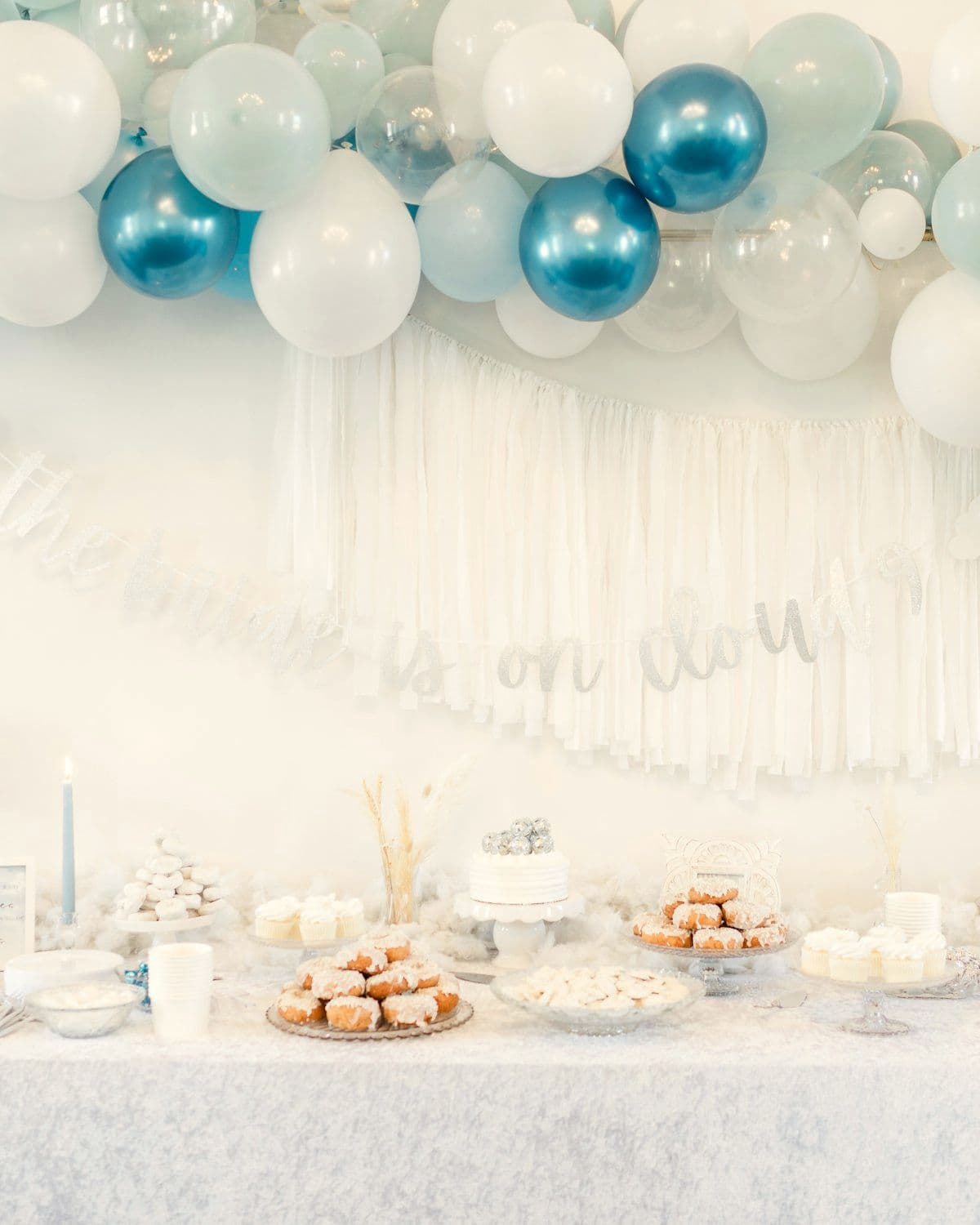 Baby shower corner styled in soft blue and white