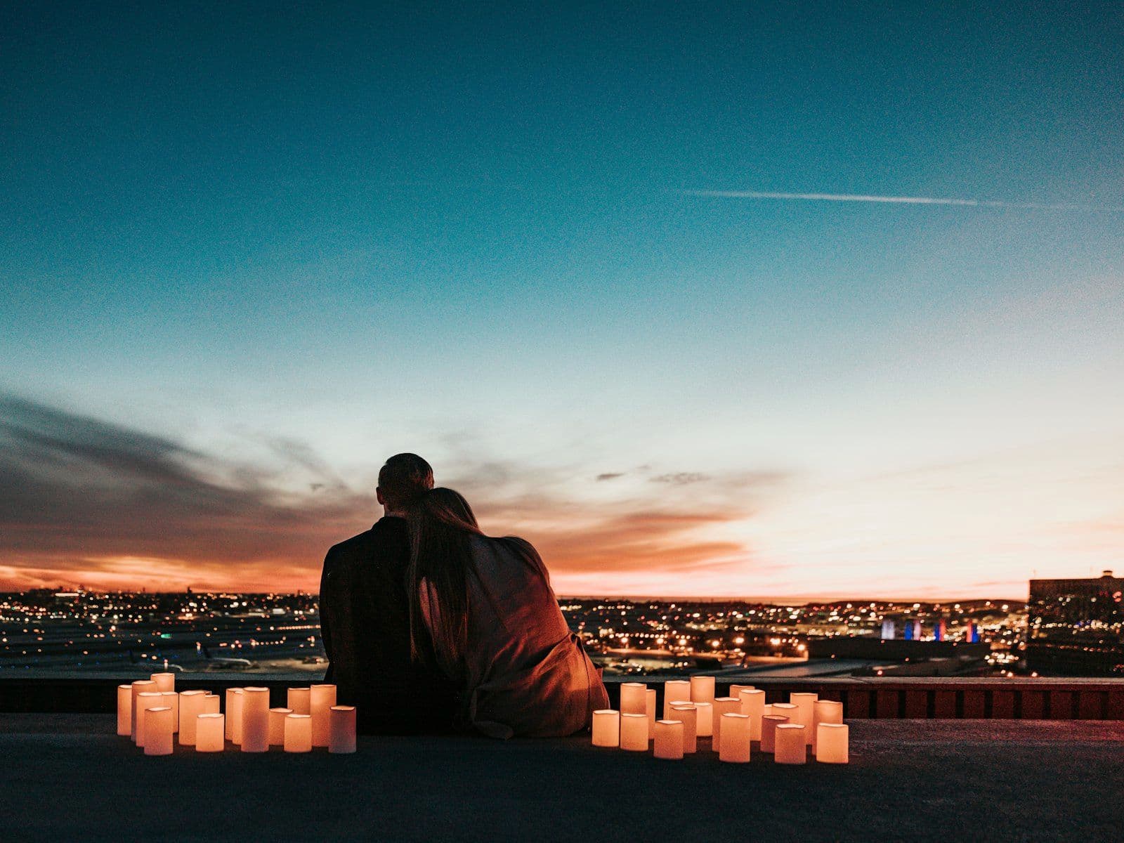Couple seated behind glowing candles at a private celebration