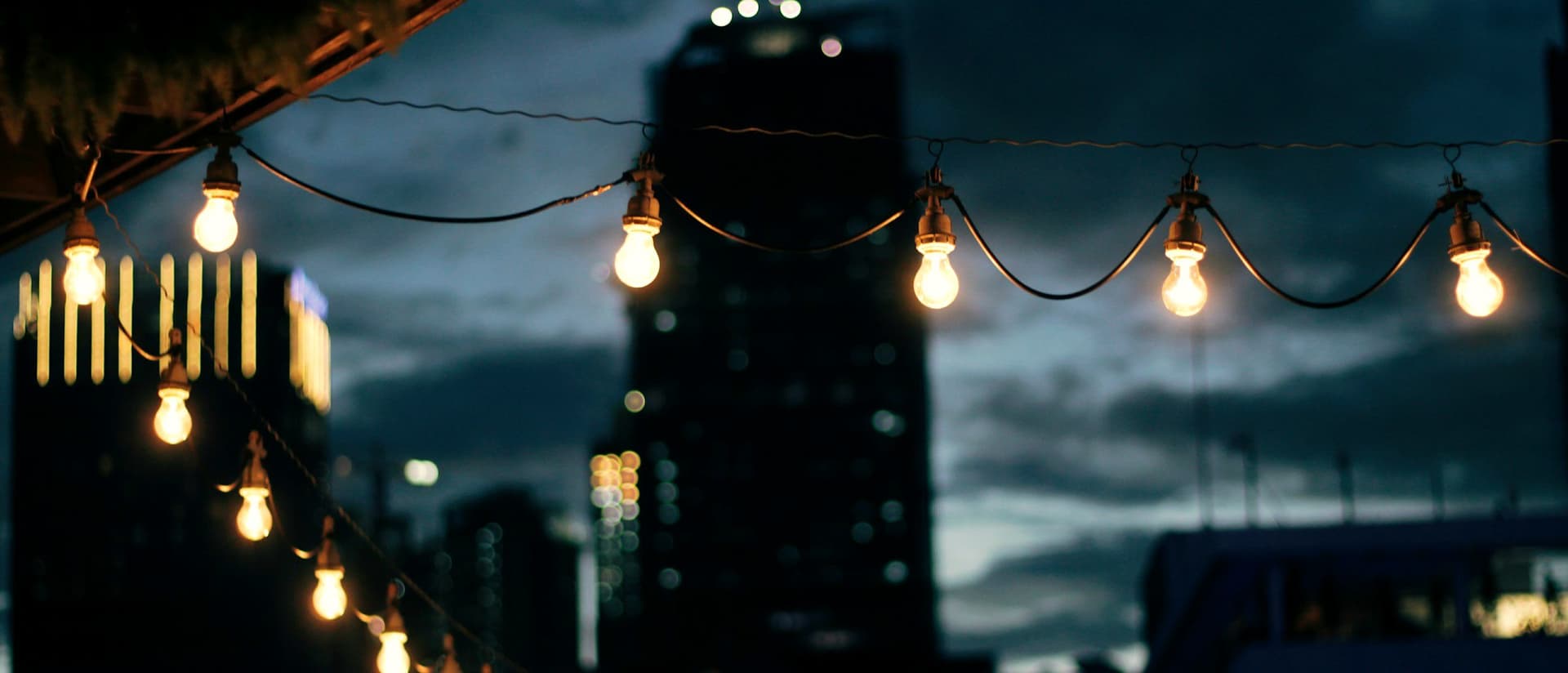 Festoon lights strung above an evening celebration