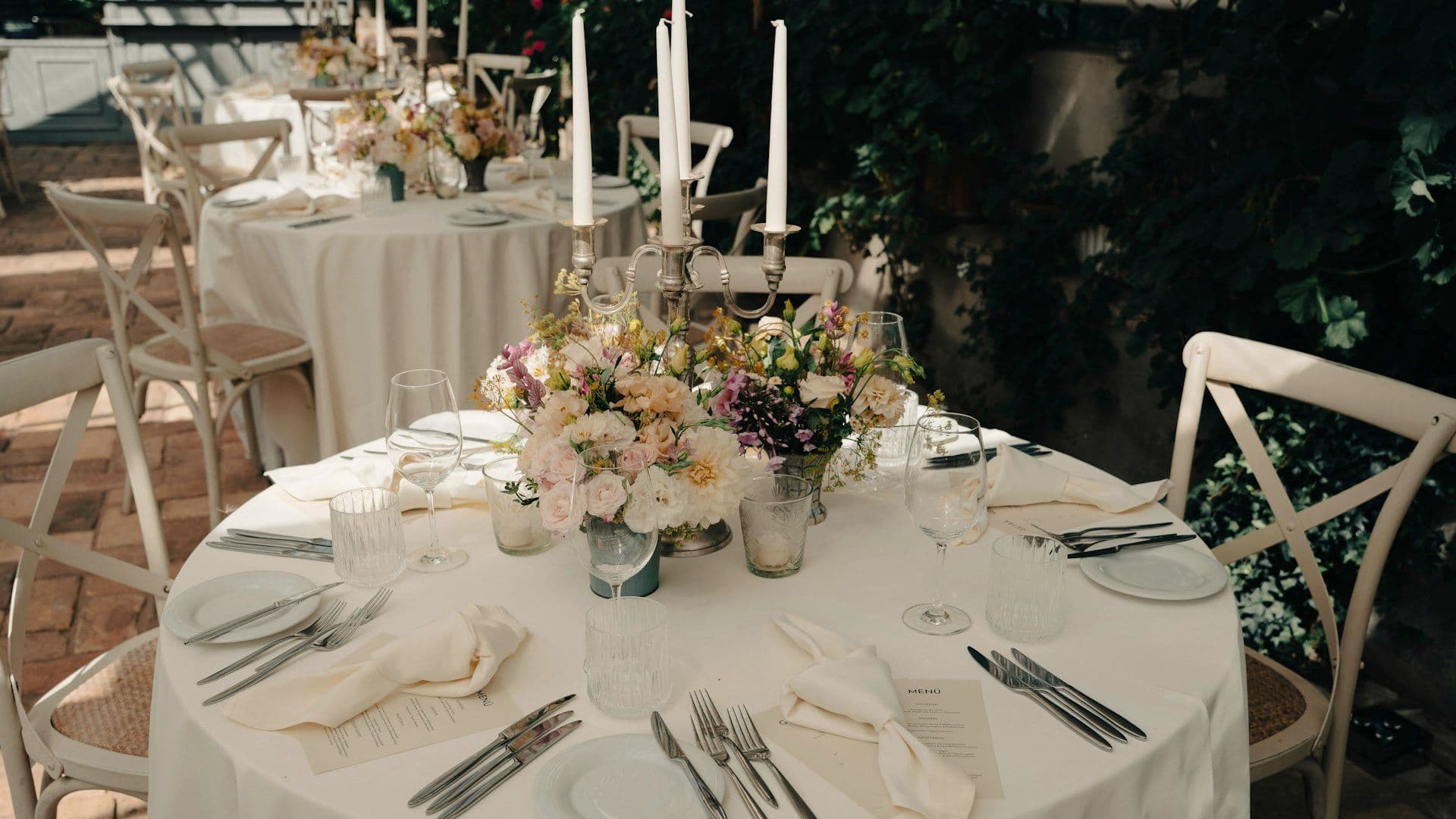 Formal place settings laid across a banquet table
