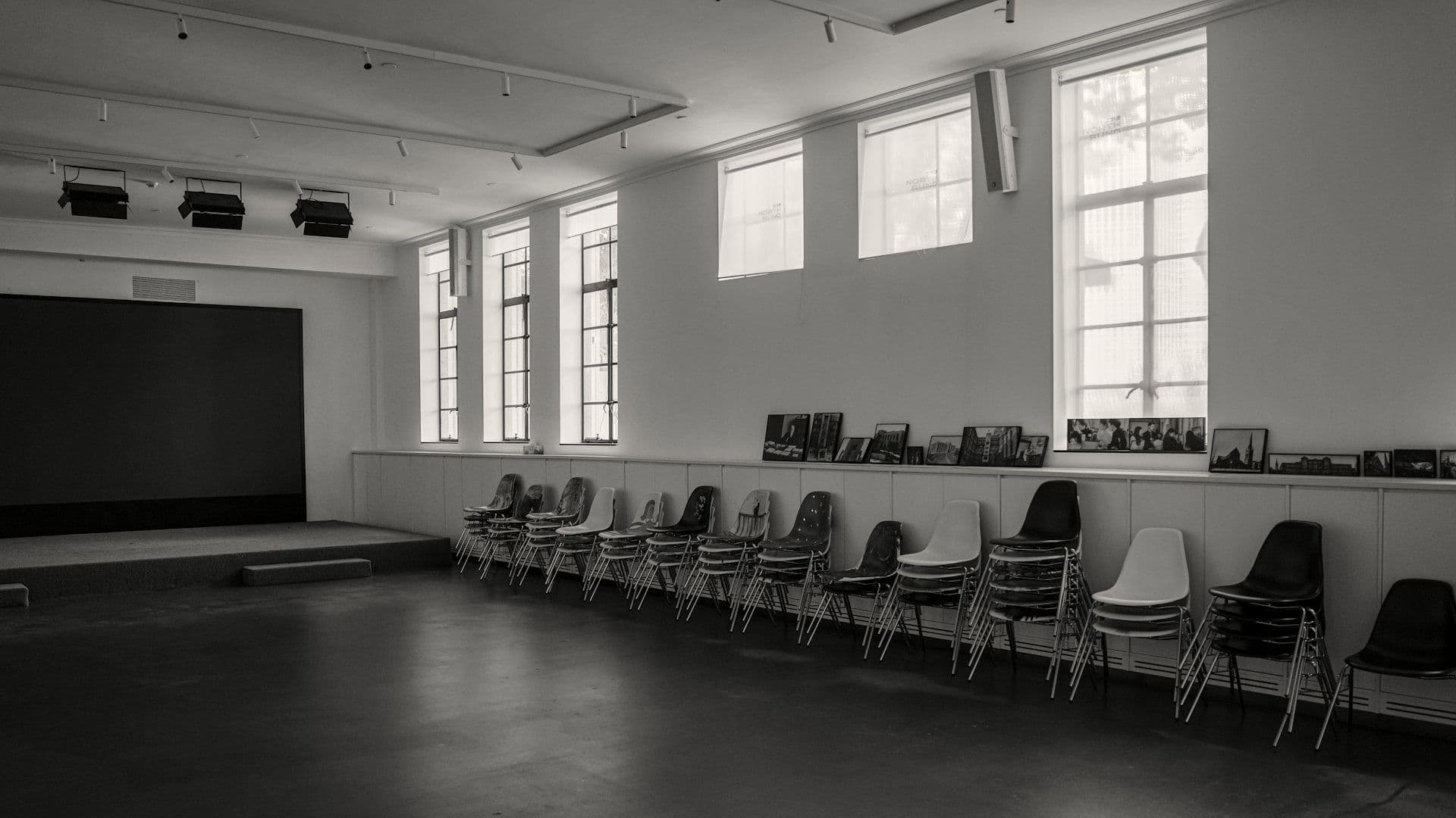 Chairs stacked in the bare hall before the build begins