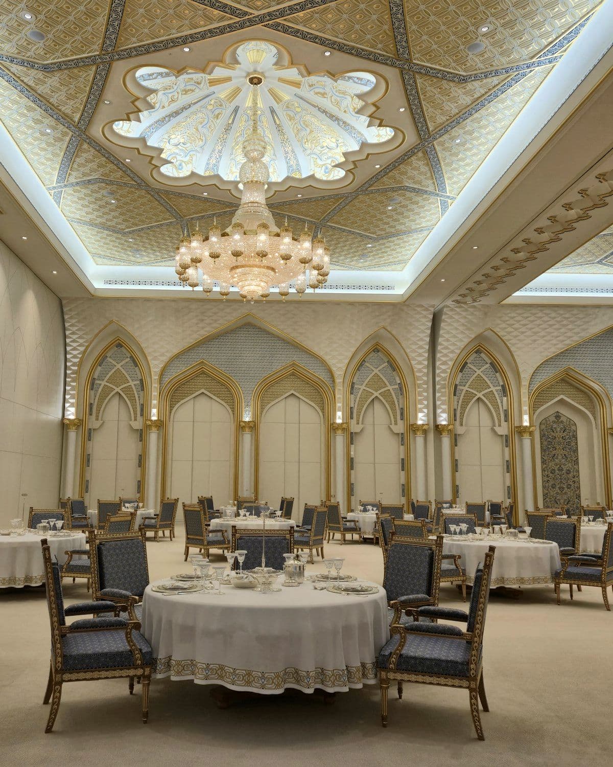Ballroom set with round tables and ornate lighting