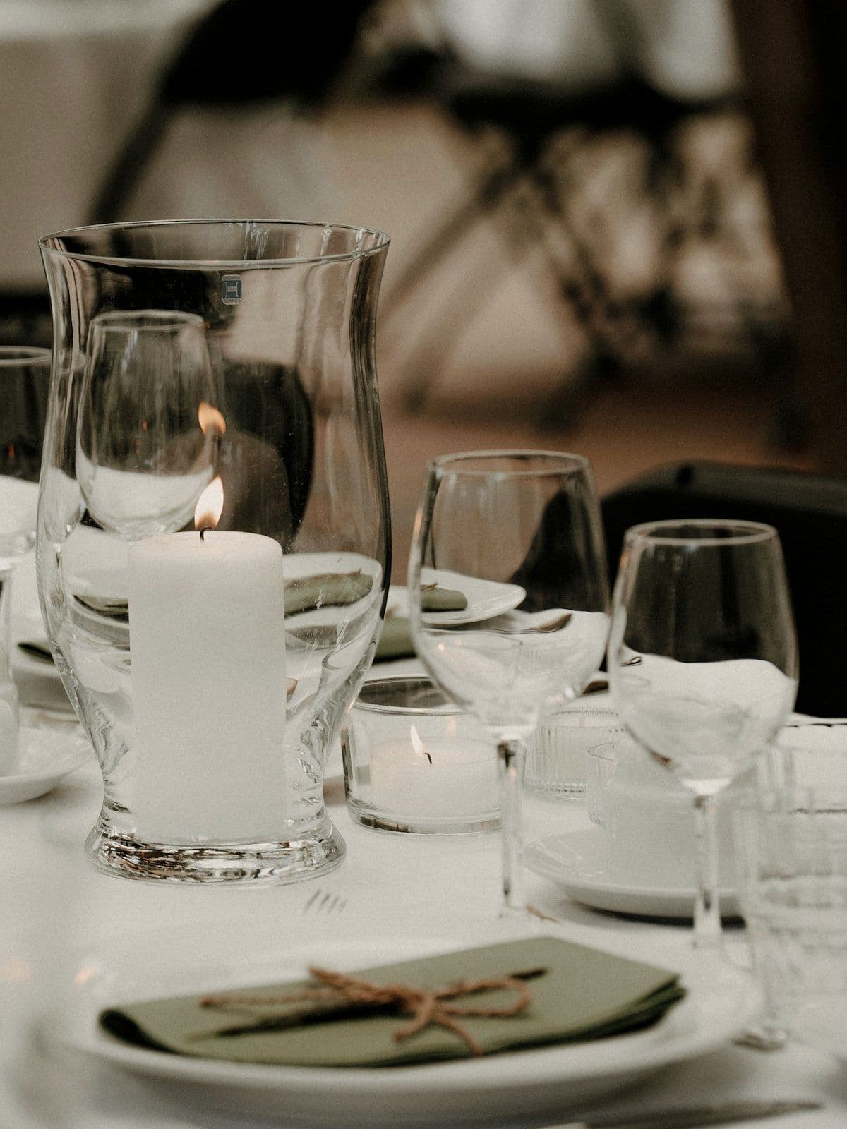 Table detail with a lit candle and low floral arrangement