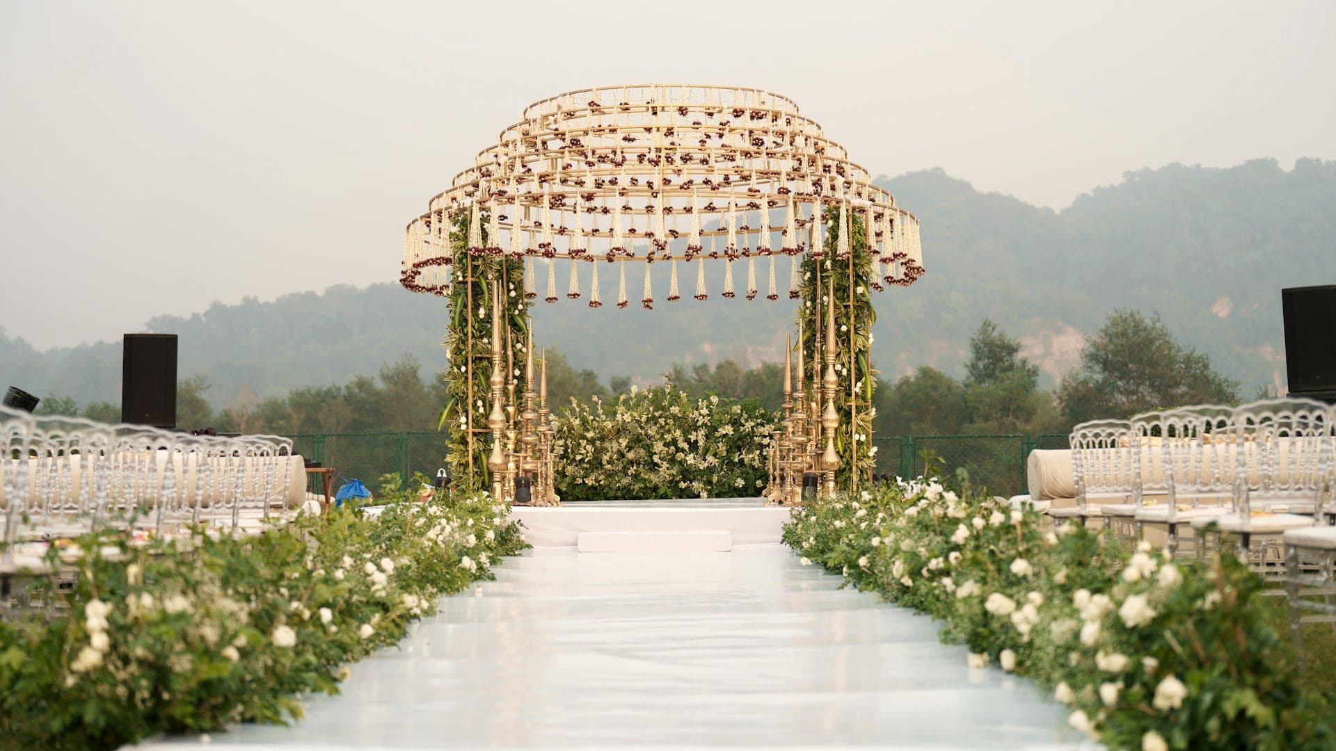 Floral arch above an aisle lined with guest seating