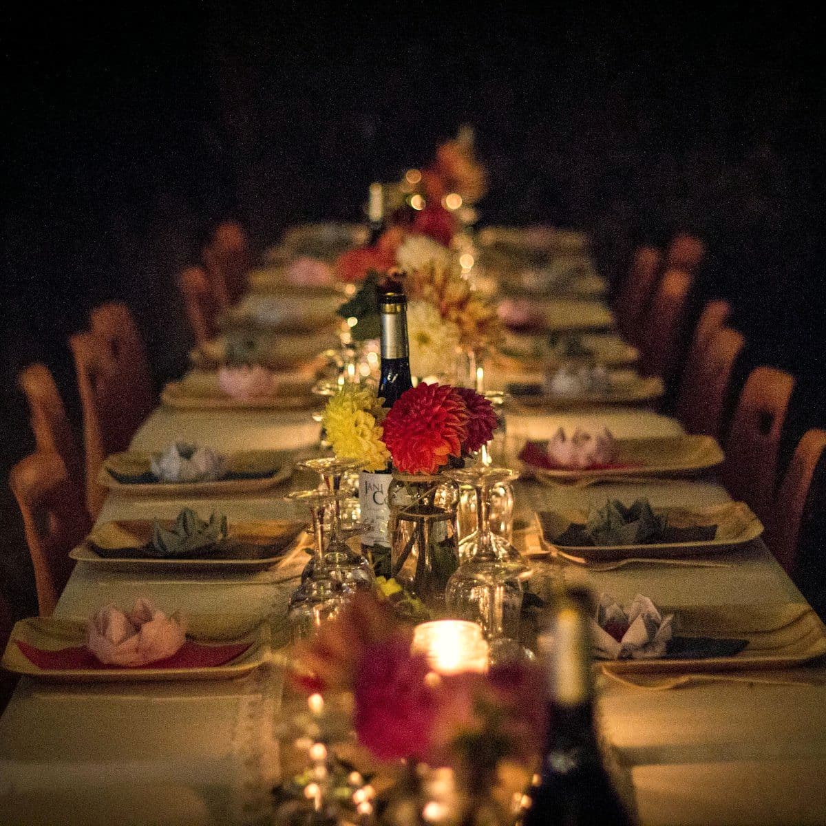 Long reception table laid with candles and floral runners
